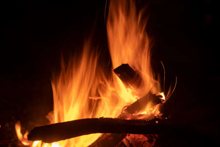 Bonfire flame at night. Yellow fire in the dark. Burning dry branches in a bright fire. Natural background of the combustion process.の写真素材