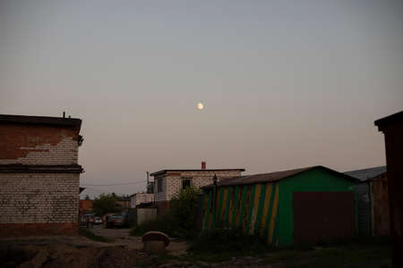 Small moon in the sky. Evening landscape outside the city. The heavenly body glows.の写真素材