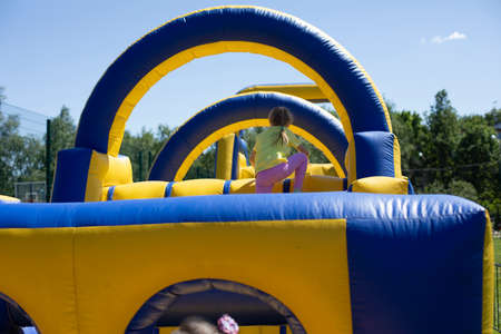 Inflatable obstacle course for fun. Trampolines for children. Fun in the park for vacationers. Yellow-blue inflatable structure on the street.の写真素材