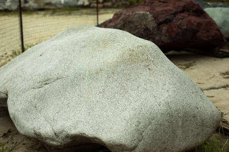 Beautiful stone in the park. A large piece of rock on the street. The cobblestones are prepared for installation in the garden. Sale of stones. Unusual stone.の写真素材