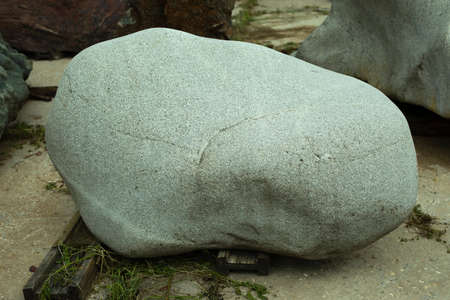 Beautiful stone in the park. A large piece of rock on the street. The cobblestones are prepared for installation in the garden. Sale of stones. Unusual stone.の写真素材