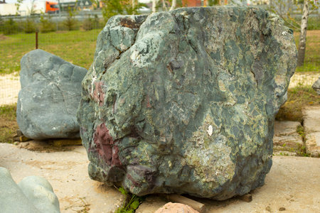 Beautiful stone in the park. A large piece of rock on the street. The cobblestones are prepared for...