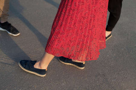 Red skirt on the girl. Summer outfit. Legs of people. Dress in the summer.の写真素材