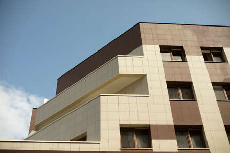 Modern building. Beige and brown cladding on the office building. Architectural details. Three floors in the frame.の写真素材