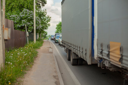 Traffic jam. Freight transport is stuck in a traffic jam on a narrow road. Cars have piled up in a queue. The traffic has stopped.の写真素材
