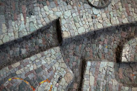 Details of the stone mosaic. Mosaic picture of pieces of stone. An architectural element that decorates the facade. Mosaic in urban architecture. Mosaic pattern from natural materials.の写真素材