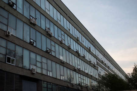 Facade of an air-conditioned office building. Industrial building in the evening. Long building with air conditioning.の写真素材