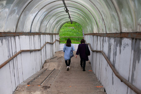 The women go down the stairs. People walk up the stairs. The pedestrian crossing ended with a staircase.の写真素材