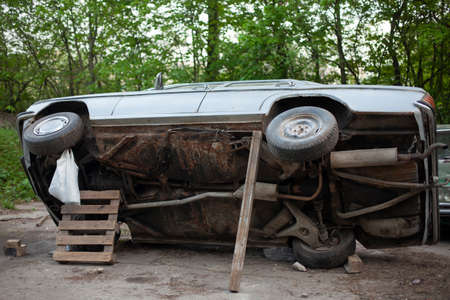The old car is being repaired. The machine has been lifted to inspect the underbody. The car has been lifted with improvised means.の写真素材