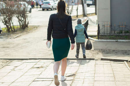 The girl from the back. The girl is walking down the street. Walking man. Pedestrian in the city.の写真素材