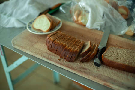 Sliced rye bread in the dining room. Food for lunch. Bread slicer board in the kitchen.の写真素材