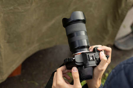 The camera is in the hands of the photographer. Hands hold the camera to take a shot. Shooting video through the lens.の写真素材