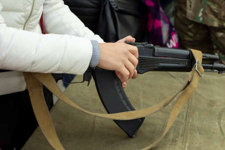 The girl loads a fire-made automatic weapon. Lesson in handling weapons. Hand on the gun. Military training of women.の写真素材