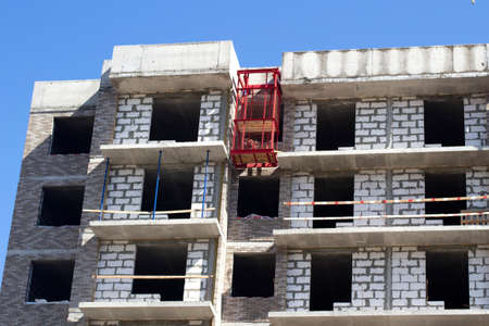 Construction of the building. Unfinished windows. The roof of a high-rise building. Bare brick block. Window openings are not lined.の写真素材