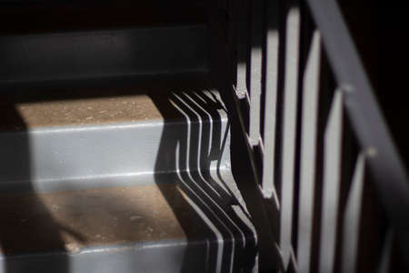Stairs inside the house. Steps made of concrete. Details of the architect of the building. Gray steps and the shadow of the railing.の写真素材