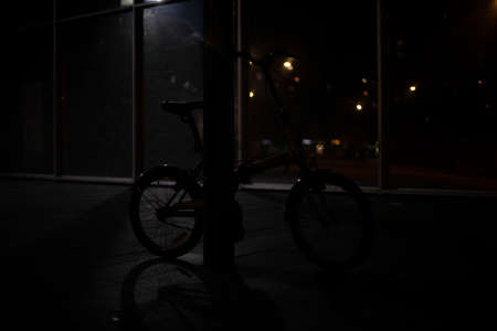 Bike in total darkness in the parking lot. The thing to steal. Abandoned bike.の写真素材
