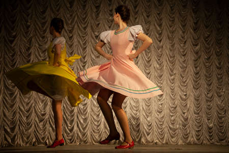 The girls dance. Russian girls dance on stage. Dance lesson in long dresses. The dancer's straming movement.の写真素材