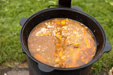 Soup in a pot. Food outside. Cooking soup on an open fire. National dish. Fatty food.の写真素材
