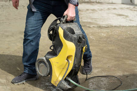 Washing for the yard. Electric water spray. Water supply device. Yellow car wash. Gardener's inventory. Pump for a strong jet of liquid.の写真素材