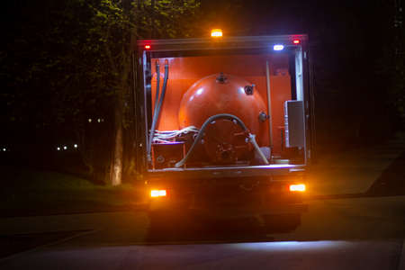 Outdoor toilet cleaning. Shit transporting machine. Taking shit out of the park at night.の写真素材