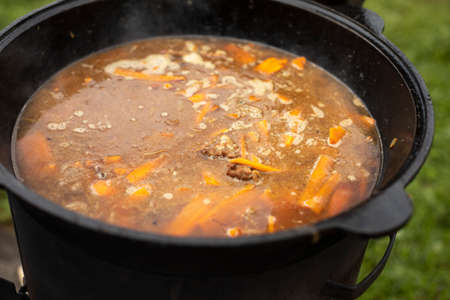 Soup in a pot. Food outside. Cooking soup on an open fire. National dish. Fatty food.の写真素材