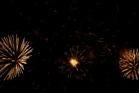 Salute in the sky. Explosion of fireworks in the night sky. Firecrackers flapping sparks in a dark space. Festive fireworks. Background with sparks from burning gunpowder.の写真素材
