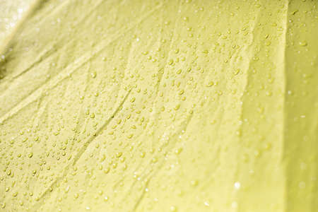 Wet cloth. Drops on yellow fabric. Wet awning from the rain.の写真素材