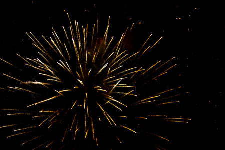 Salute in the sky. Explosion of fireworks in the night sky. Firecrackers flapping sparks in a dark space. Festive fireworks. Background with sparks from burning gunpowder.の写真素材