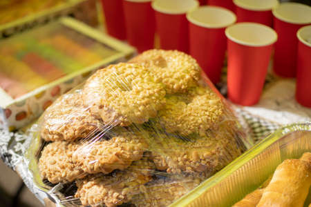 Sweets packed in film. Sale of delicious food. Boxes of sugar treats. Food stall outside.の写真素材