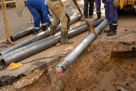 Replacement of sewer pipes. Laying gas pipes in the ground. Workers are establishing new communications. Construction work on the street.の写真素材