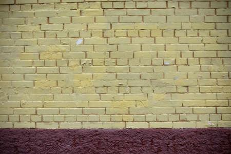 Brick wall painted with yellow paint. The texture of the wall of the building. Painted surface of the house.の写真素材