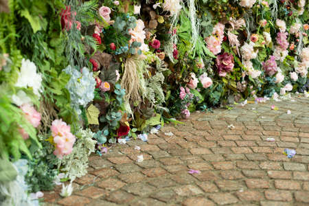 A wall of flowers. Decoration of flowers in the park. Rose buds are put together in one large texture. Place for photography.の写真素材