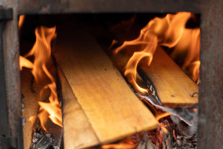 Firewood burns in the stove. Burning wood. Furnace heating. Kindling a tree in the hearth.の写真素材