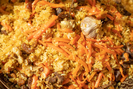 Rice with carrots and garlic. National dish of Uzbekistan. A delicious meal outside. Pilaf with meat.の写真素材