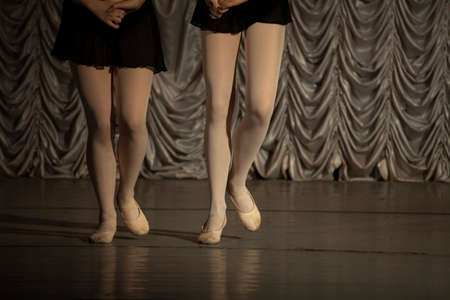 Two ballerinas. The girls hold hands. Pair dance. Rehearsal of a dance number. A lesson in beautiful movements.の写真素材