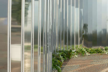 Mirror wall in the park. Architectural element to decorate the city. Reflective surface. Many mirrors stand in a row at an angle.の写真素材