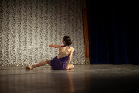 Dancer on stage. A girl in a purple dress. Performance of a ballerina. Dance lesson