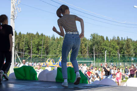 Girls on stage. Dance lesson. A holiday in the city park. Crowd of spectators, sunny dayの写真素材