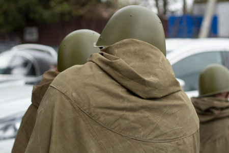 Three men in Soviet uniform during the Second World War, view from the back. Green overcoat and...