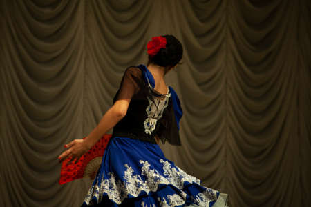 Gypsy dance. A girl in a dress performs on stage. Blue dress in motion. Choreography lesson.の写真素材