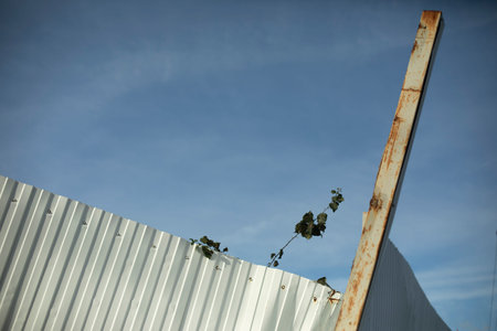 Broken stainless steel fence. Damaged fencing. Crudded metal.