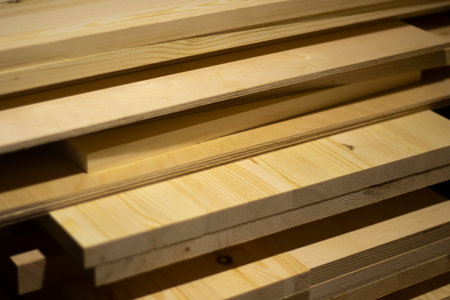 Boards in the carpentry workshop. The tree lies in a pile. Prepared wood for processing.