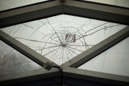 cracks in window. Hole in surface. broken structure. result of vandalism.