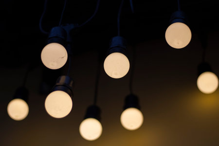 lamps in dark. yellow lamps. Garlands hang in row. interior details. Glam.