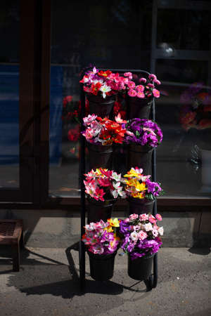 Flowers are sold on the street. Artificial flowers for cemetery. Details of flower shop. Flowers made of plastic. Trade in Russia.の写真素材