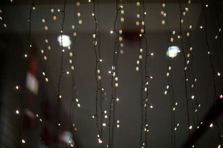 Garlands on glass. small lamps. LEDs decorate window.の写真素材