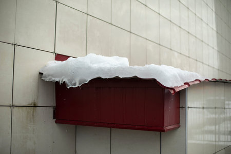 Ice on roof. Snow on building. icy wall. Winter weather. Thawing snow.