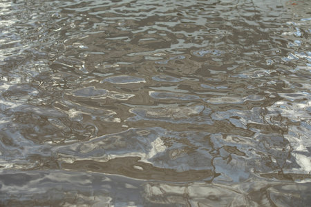 texture of water. surface of puddle. small waves. reflection in water.