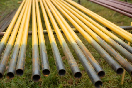 Pipes lie in row. steel parts. Yellow pipes for gasification. Urban communications.の写真素材