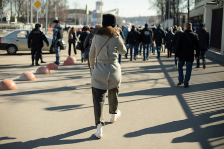 Girl walks through the city. Woman on the street. Spring clothes on person. Walking along road. lot...